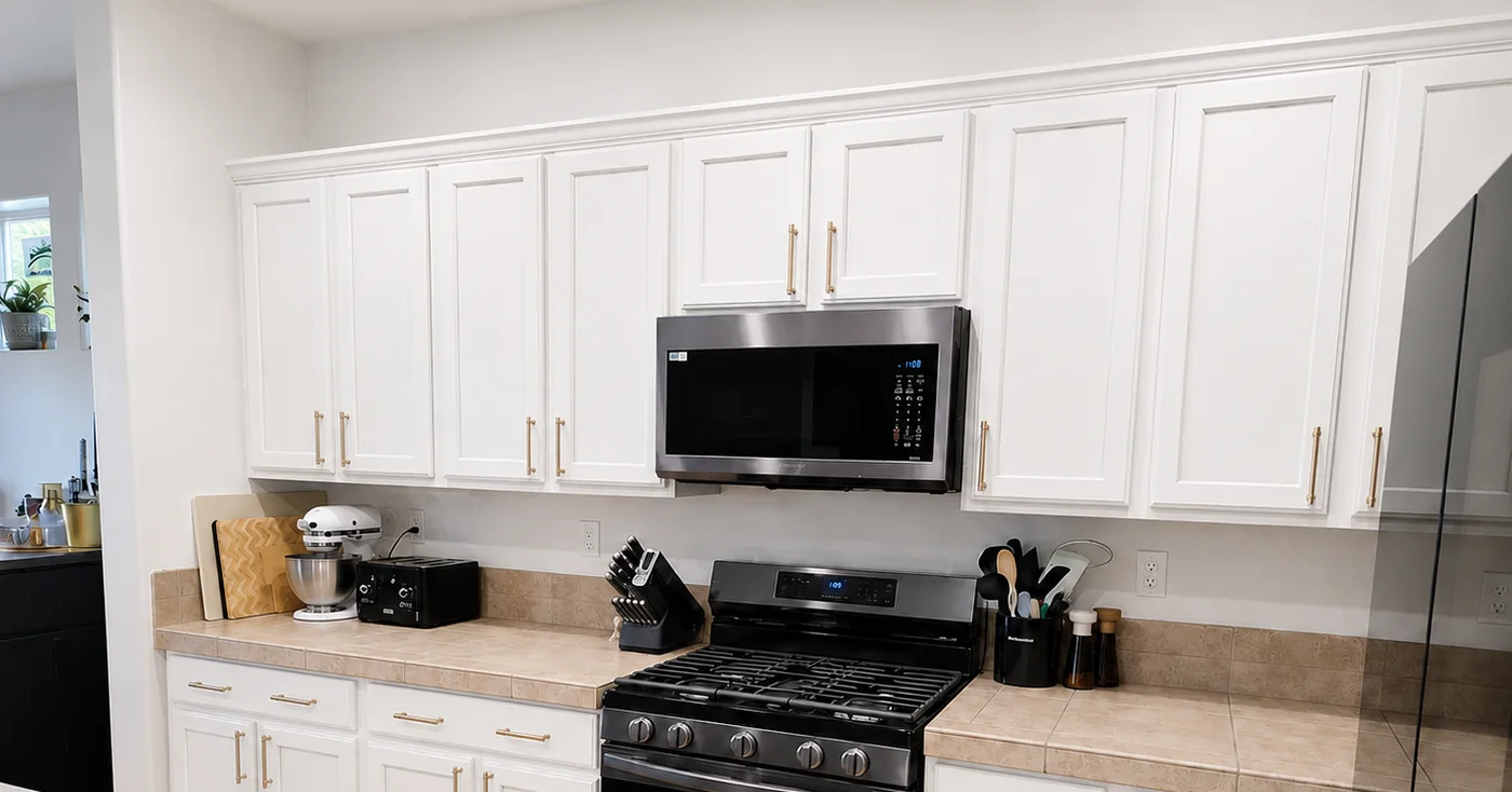 White kitchen cabinets before a Riversons Painting cabinet refinishing color transformation