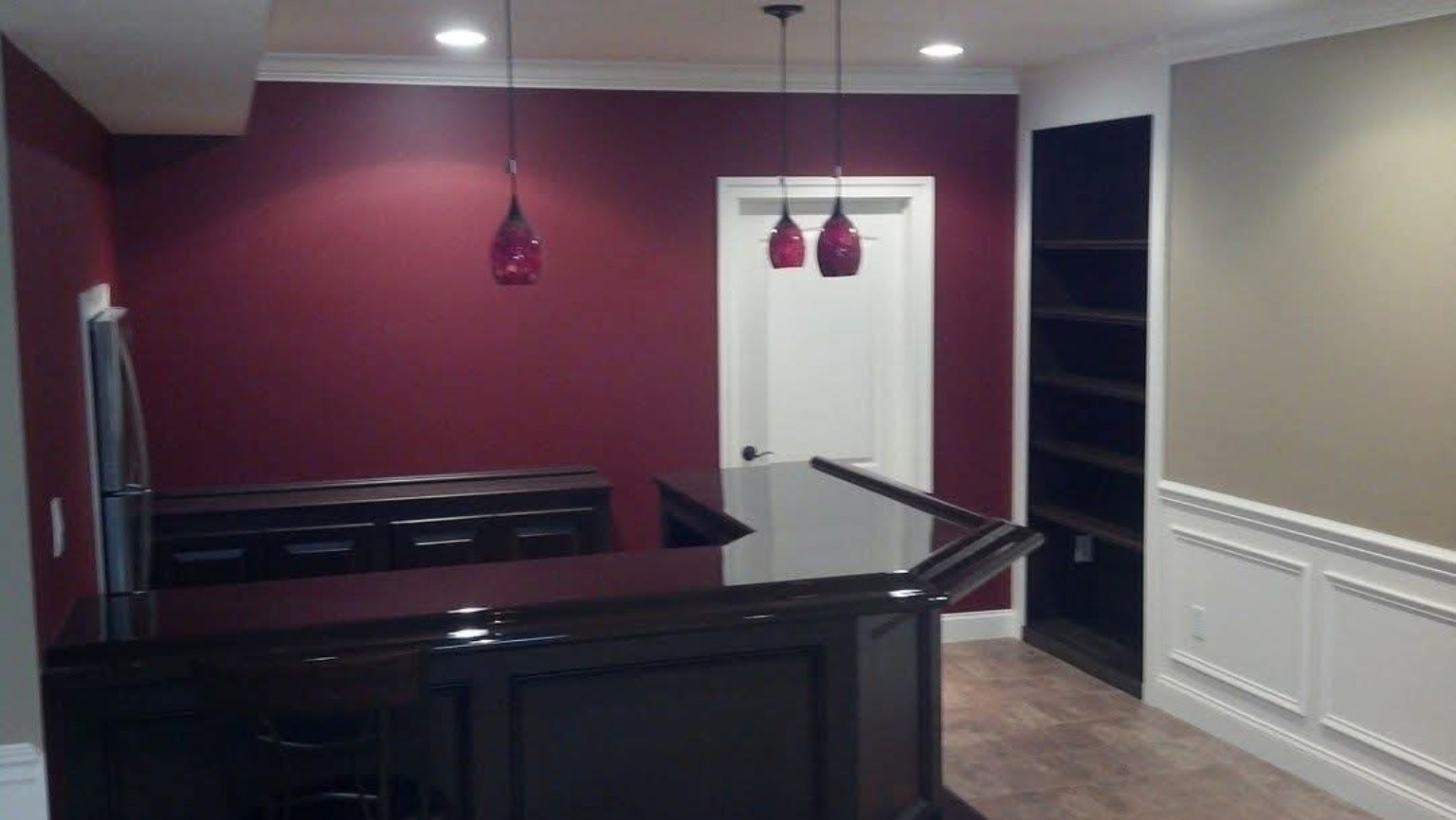 Dark painted built-in cabinetry and bar finish work